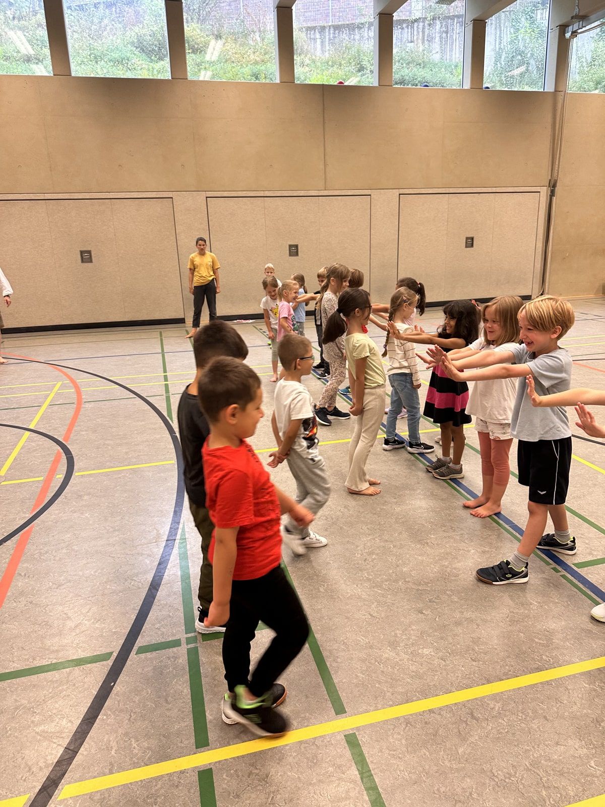 Kinder stehen sich in der Turnhalle gegenüber