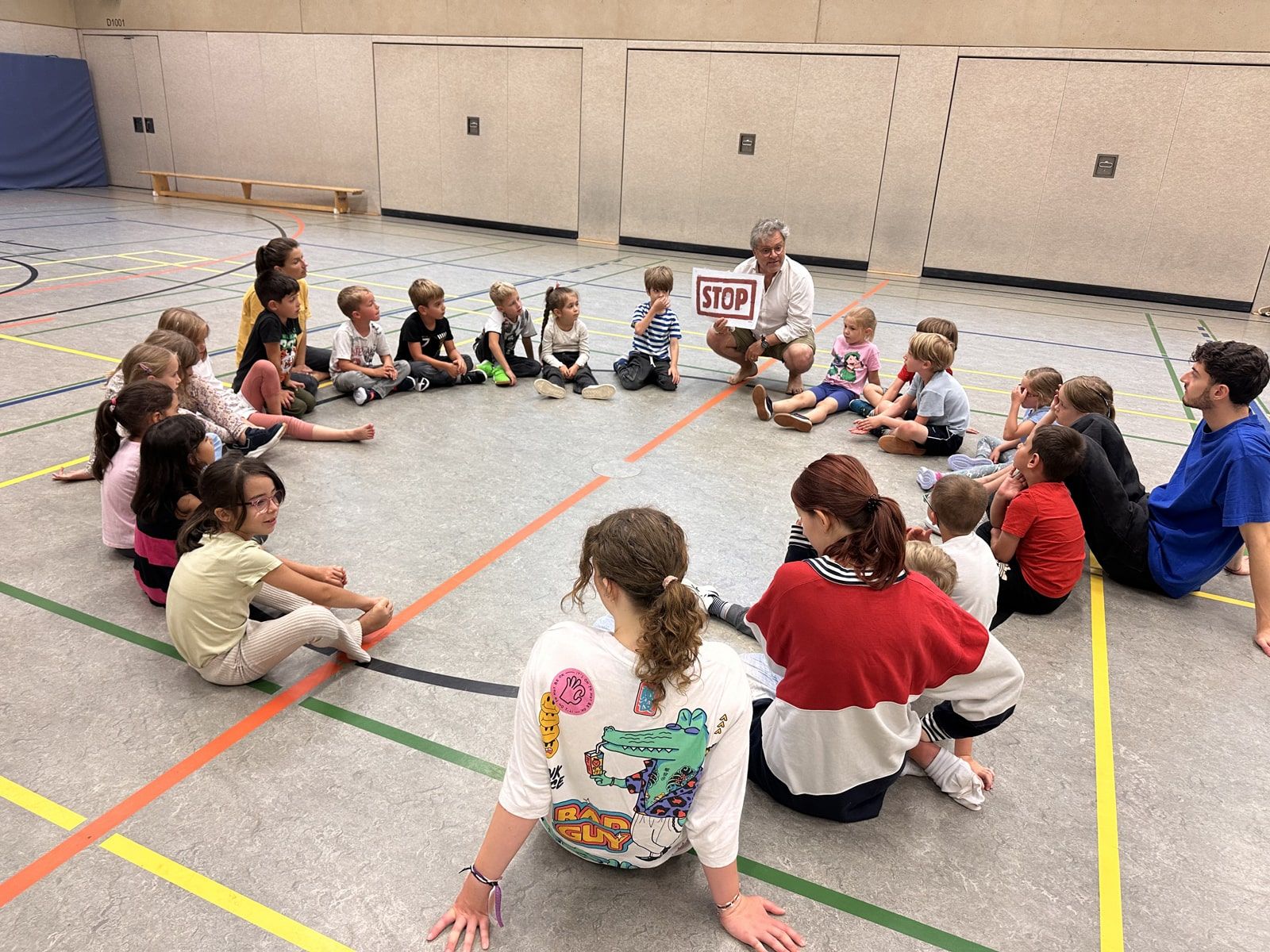 Kinder sitzen im Kreis in der GGS Turnhalle