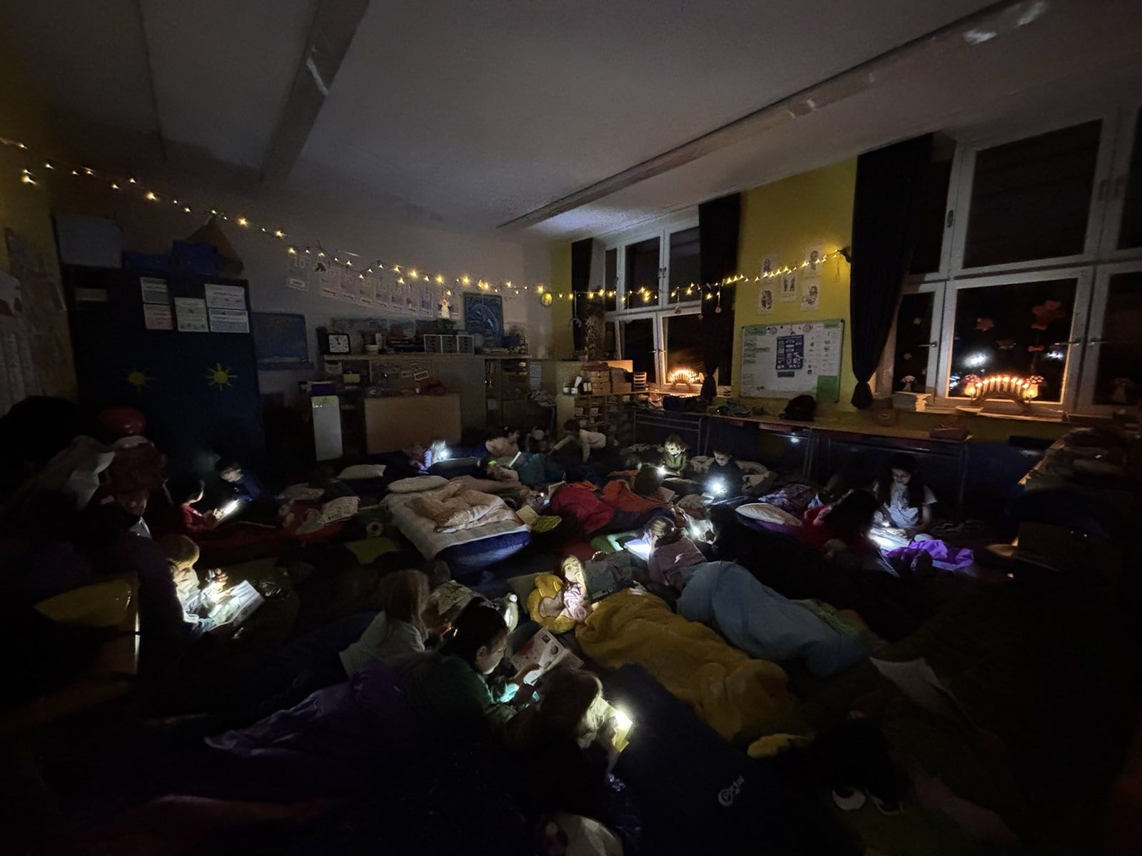 Kinder mit Taschenlampen lesen Bücher in ihren Schlafsäcken