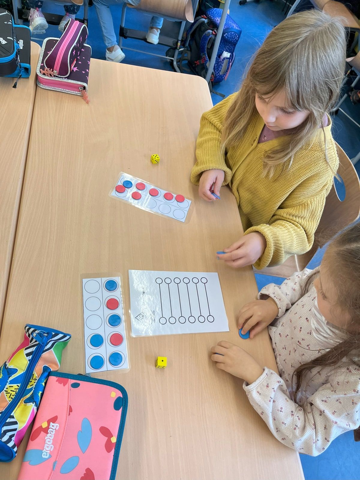 Zwei Kinder spielen Hamstern am Tisch