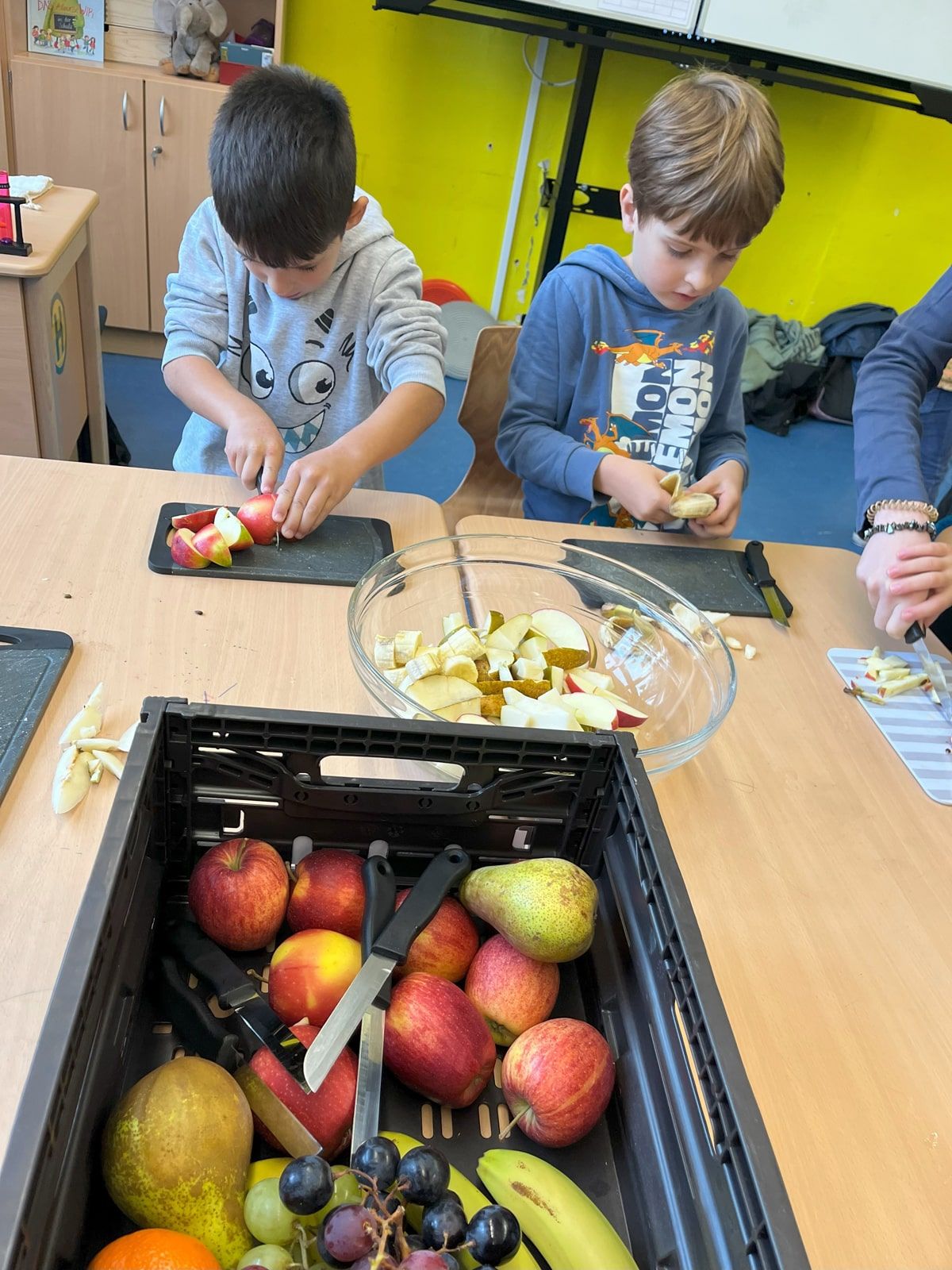 Zwei Kinder schneiden Obst